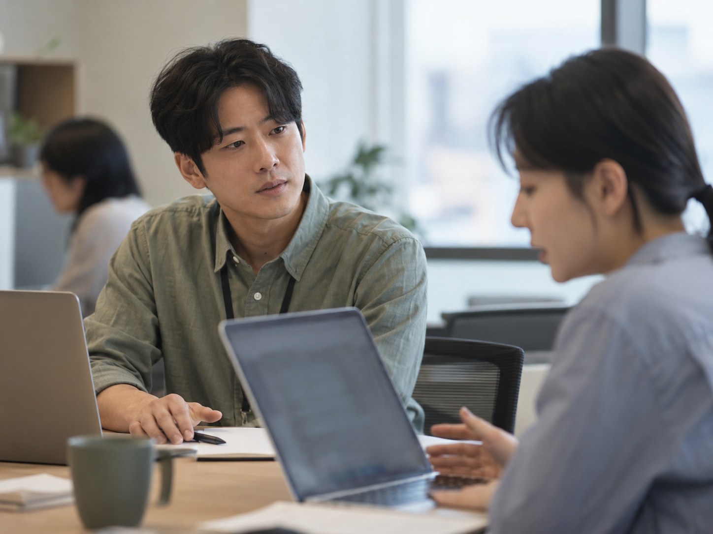 동료가 노트북을 보며 막힌 일을 설명하는 동안, 바로 거들 수 있었던 직원이 펜을 내려놓고 끝까지 듣고 있다 — 버릇을 버리지 않고 참는 때를 정해 두면 나서기 전에 한 번 멈출 수 있다